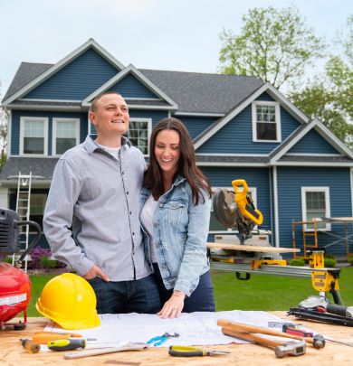 Couple standing in front of home being built