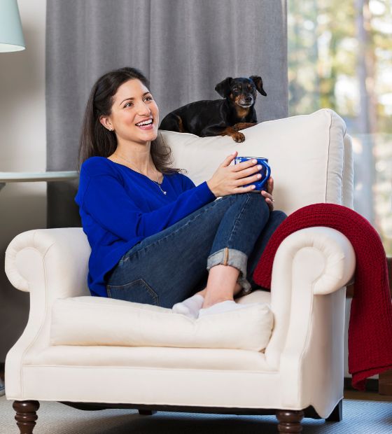 Woman sitting on couch with dog