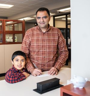 Father and young son at a bank teller counter
