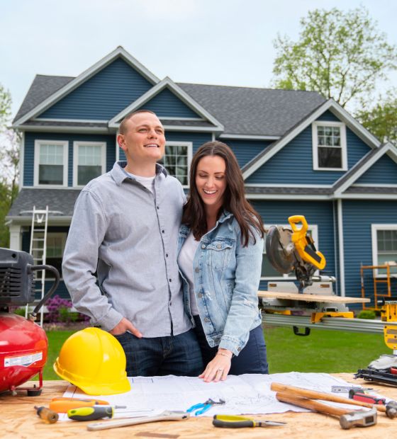 Couple standing in front of house construction