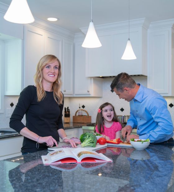 mother and father cooking with daughter in kitchen