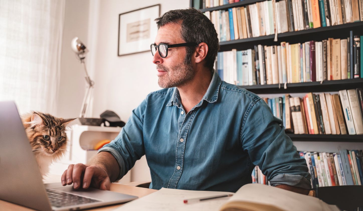 Man on his computer sitting with cat
