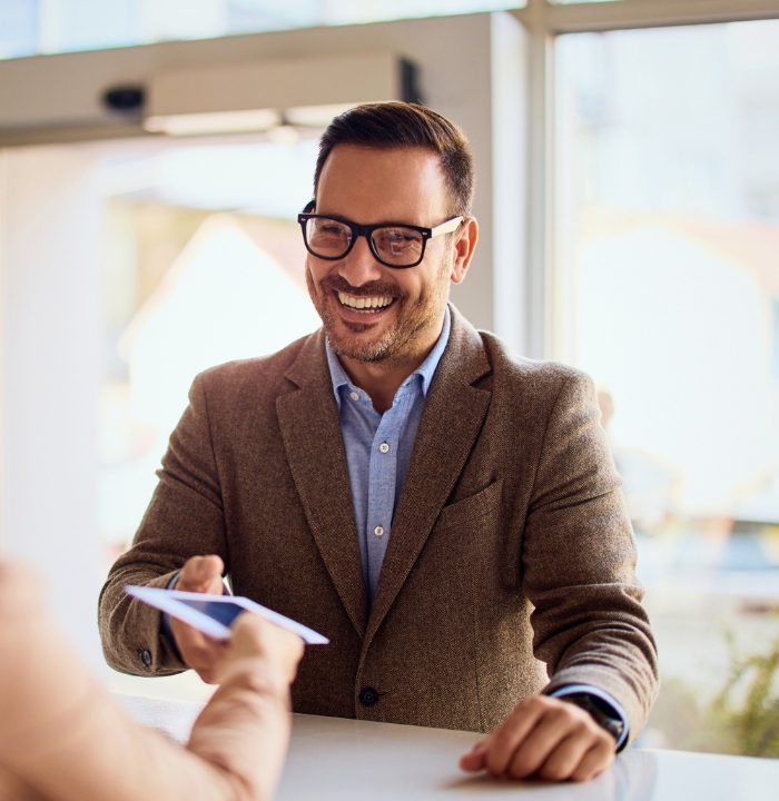 Man smiling and grabbing paper at counter