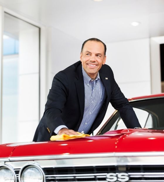 Man wiping down a vehicle in a car dealership 