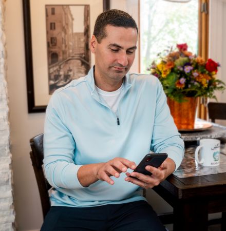 Man sitting at table on his phone