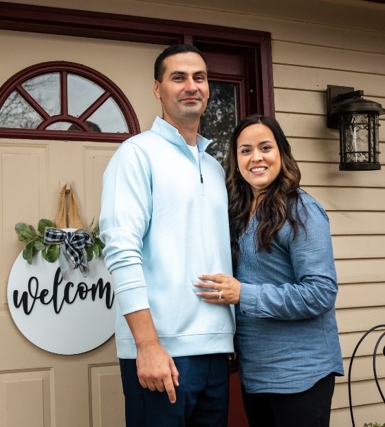 Couple standing outside of their house