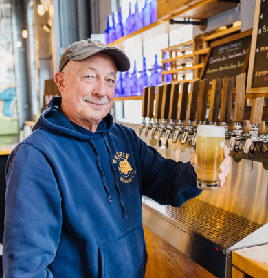 Mark, co-founder of Reverie Brewing holding a beer