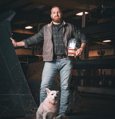 man standing with welding mask and dog