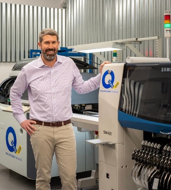 Man standing in front of manufacturing machinery 