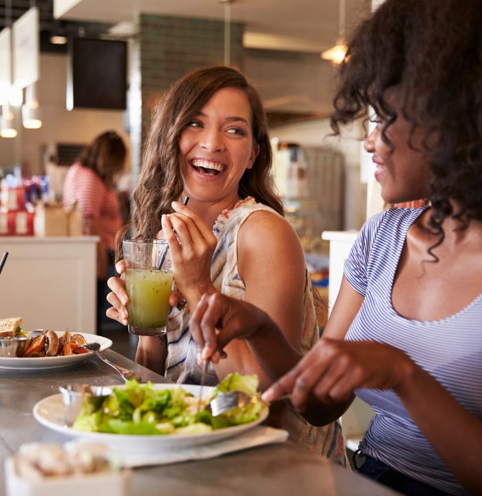 Two women eating lunch and laughing together